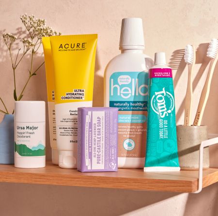 A shelf with a group of products, including deodorant, conditioner, a bar of soap, mouthwash, toothpaste, and a toothbrush.